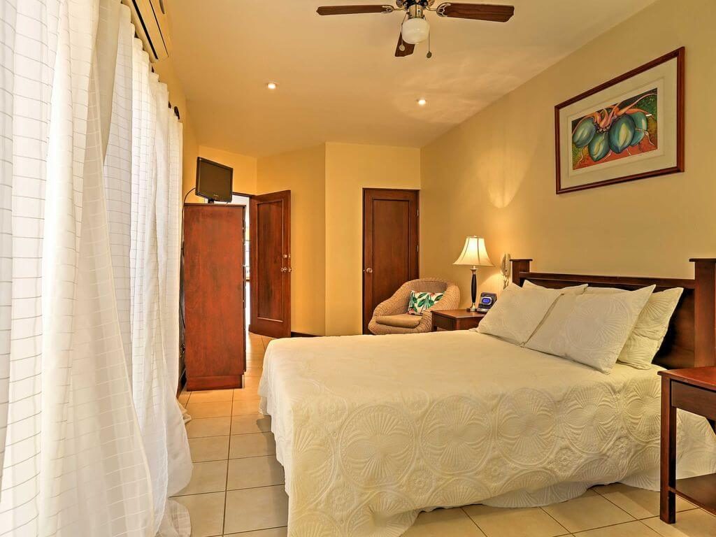 Air-conditioned master bedroom with queen-size bed, en suite bath, patio access, and walk-in closet